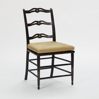 A SET OF DINING CHAIRS CONSISTING OF FOUR SIDE AND TWO ELBOW CHAIRS WITH PIERCED LADDERBACKS, IN A BLACK PAINTED FINISH WITH FLORAL DETAILS. EARLY 20TH CENTURY. WITH NEW SEAT CUSHIONS.
