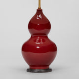 A PAIR OF 1970'S DOUBLE GOURD VASES WITH A SANG DE BOEUF GLAZE IN THE CHINESE MANNER, WIRED AS LAMPS.