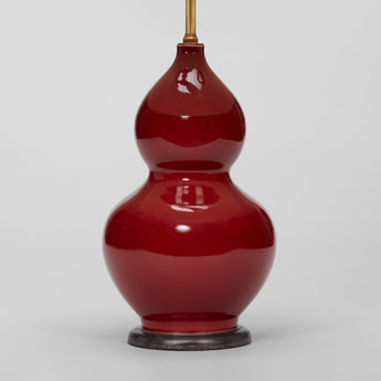 A PAIR OF 1970'S DOUBLE GOURD VASES WITH A SANG DE BOEUF GLAZE IN THE CHINESE MANNER, WIRED AS LAMPS.