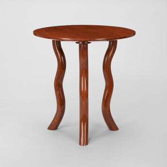 LOW ROUND TEAK TABLES WITH SERPENTINE LEGS.