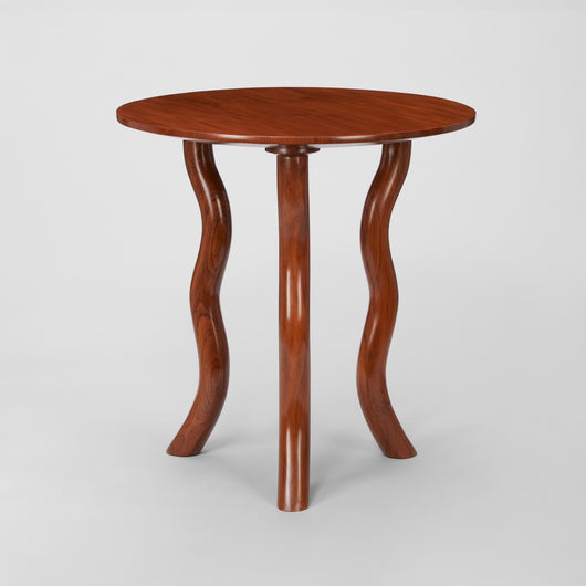 LOW ROUND TEAK TABLES WITH SERPENTINE LEGS.