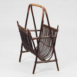 A BAMBOO AND RATTAN MAGAZINE STAND WITH A-FRAME SUPPORTS AND CARRYING HANDLE.