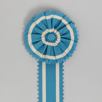 ROSETTE AND SASH MADE UP IN THE DARK BLUE PICOT BRAID.