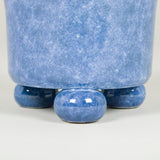 A small mottled tin glazed earthenware planter on bun feet in manganese or blue.