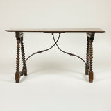 A rectangular table with hardwood parquetry top on bobbin-turned side supports and curved iron stretchers. Iberian probably 19th century.