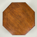 An octagonal mahogany hall table with eight turned legs joined by low-level stretchers. Late 19th century.