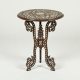 A late 19th century Syrian inlaid table with a round top on four joined and scrolled supports.