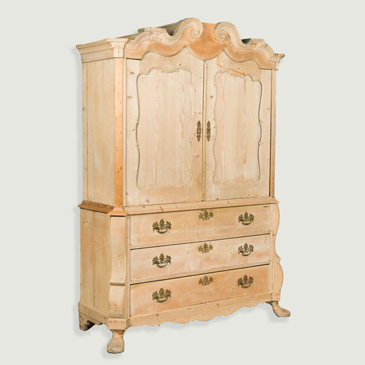 A large stripped pine armoire with shaped crest over panelled doors and three-drawer  bombe base. Circa 1760 Dutch.