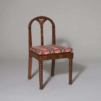 A pair of small Gothic style side chairs with arched backs, spiral turned front legs and traces of old paintwork. Late 19th century.