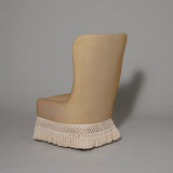 A bespoke made Friar’s chair in a cream stripe fabric, the base finished with a woven fringe..
