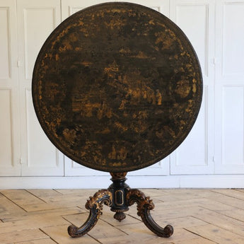 A 19TH CENTURY CHINESE EXPORT CENTRE TABLE WITH A LACQUERED AND DECORATED TILT TOP ON A CARVED AND GILDED BASE.