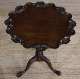 AN ENGLISH 18TH CENTURY GEORGE III TRIPOD TABLE WITH A PIE CRUST TOP WITH SCALLOP SHAPED DETAILS AND TRIFORM BASE.