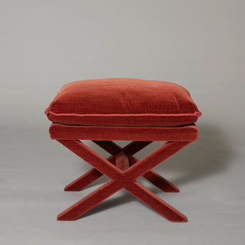 A pair of modern velvet-covered X-frame stools with seat cushions.