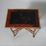 An early 20th century rectangular bamboo table with a lacquer panel top decorated with birds and foliage.