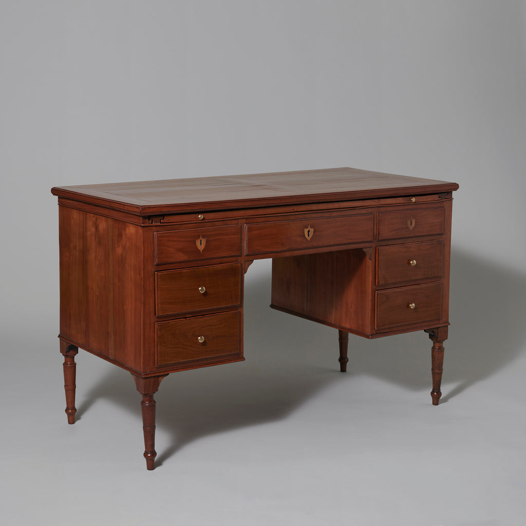 An early 19th century Italian fruitwood kneehole desk with sliding to