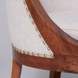 A pair of fruit-wood framed tub chairs with sabre legs, French circa 1810.