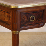 AN EARLY 20TH CENTURY FRENCH MAHOGANY DESK WITH REEDED LEGS, FLAME MAHOGANY VENEERED PANELS, BRASS MOUNTS AND ORIGINAL LEATHER TOP.