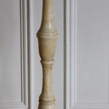 A MID-20TH CENTURY SPANISH SOLID ALBASTER STANDARD LAMP MADE UP OF TURNED AND POLISHED SECTIONS ON A TURNED ROUND BASE.