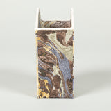 A fine cartonnage pencil holder decorated in marbleised and small scale patterned papers.