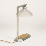 A small 1930’s chromed brass desk lamp with an octagonal base and glass shade.