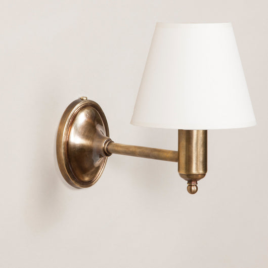Fixed arm wall light with oval back plate. Antiqued Brass.