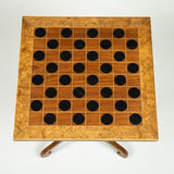 An early 19th Century mahogany square table with a games board top, turned support and tripod base.