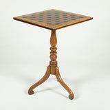 An early 19th Century mahogany square table with a games board top, turned support and tripod base.