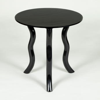 Low round teak tables with serpentine legs in an ebonised finish.