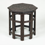 A small octagonal densely-carved hardwood table with folding base, probably Indian late 19th/early 20th century.