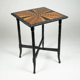 An Anglo Indian ebony table with a specimen inlaid top in a radiating design with a gadrooned edge and with spiral carving to the legs.