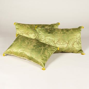 Three cushions made from 17th century brocatelle finished with yellow tassels.