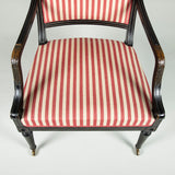 A George III black painted library armchair with curved square back and spiral-twisted front legs. Circa 1800.