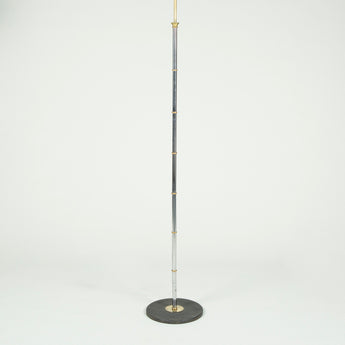 A Bagues brass ringed and polished steel floor lamp with a matt black round iron base.  French mid 20th century