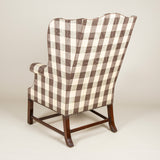 A high-backed Chippendale period wing arm-chair with mahogany moulded legs and cross-stretcher. English, circa 1770.