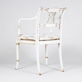 An elegant ivory-lacquered and gilt Sheraton style open armchair with caned seat. Probably 2nd half of the 19th century.
