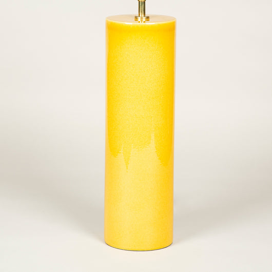 A pair of tall cylinder-shaped pottery lamps with a deep yellow glaze.