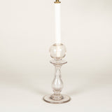 A clear glass baluster shaped candlestick topped by a hollow glass orb candleholder, now wired as a lamp.