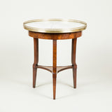 A late 19th century circular French walnut occasional table with a brass gallery and an inset marble top, circa 1900.