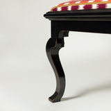 A rectangular stool with padded seat and ebonised 19th century rectangular base with cabriole legs.