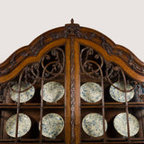 A  late 18th Century Dutch oak China display cabinet, the glazed upper part with arched top and carved leaf and acorn swags and scrolls, the lower part with two panelled doors. Circa 1780.