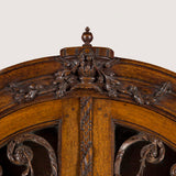 A  late 18th Century Dutch oak China display cabinet, the glazed upper part with arched top and carved leaf and acorn swags and scrolls, the lower part with two panelled doors. Circa 1780.