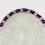 An oval mirror with alternating blue and clear pyramidal brilliants.